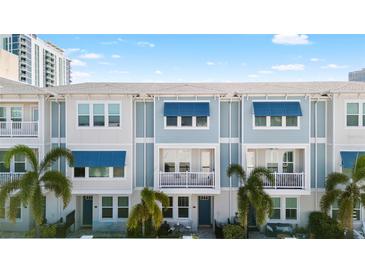 Beautiful townhome exteriors featuring blue awnings, private balconies, and lush tropical landscaping at 845 Burlington N Ave, St Petersburg, FL 33701
