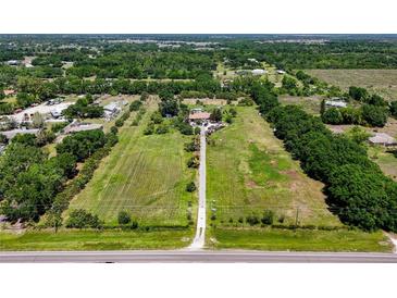 Expansive aerial view of a large lot with green fields, mature trees, and a home nestled in the center at 16305 E State Road 64, Bradenton, FL 34212