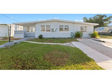 Inviting single-story home featuring a well-maintained lawn, and a clean, painted exterior in a lovely neighborhood at 221 Duxbury Ave, Port Charlotte, FL 33952