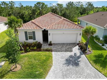Beautiful single-story home with a red tile roof, manicured landscaping, and a paver driveway at 412 Daylily Blvd, Nokomis, FL 34275