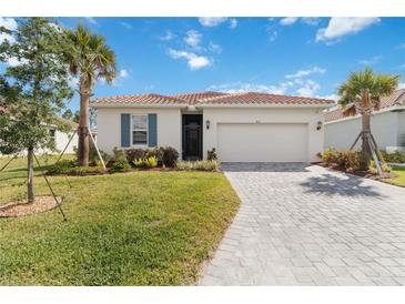 Charming single-story home featuring a paved driveway and a well-manicured lawn at 412 Daylily Blvd, Nokomis, FL 34275