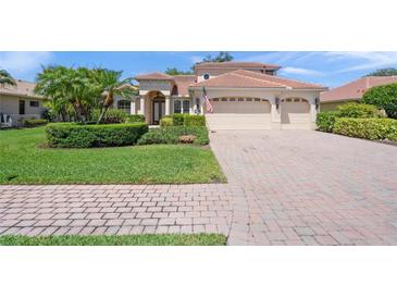 Charming two-story home with lush landscaping and a paver driveway leading to a three-car garage at 4668 Tuscana Dr, Sarasota, FL 34241