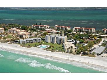 Stunning aerial view of beachfront condos, pool, and the Gulf of Mexico's turquoise waters at 4835 Gulf Of Mexico Dr # 106, Longboat Key, FL 34228