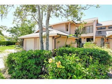 Charming townhome exterior featuring lush landscaping and a private two-car garage at 5230 Landings Blvd # 101, Sarasota, FL 34231