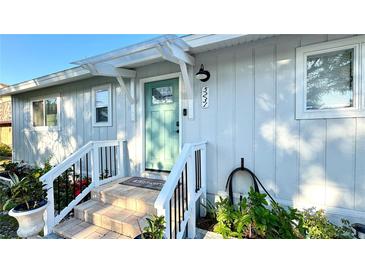 Charming home featuring a covered front porch, a stylish teal door, and well-maintained landscaping at 5231 32Nd E St, Bradenton, FL 34203
