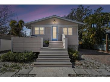 Charming home featuring a welcoming front porch and serene evening ambiance at 652 Ohio Pl, Sarasota, FL 34236