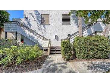 Exterior shot of a two story condo building with wooden stairs, walkway, and garden landscaping at 811 Oak Dr # 811, Bradenton, FL 34210