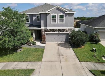 Charming two-story home with a stone-accented facade, landscaped yard, and a spacious driveway at 10934 79Th E St, Parrish, FL 34219