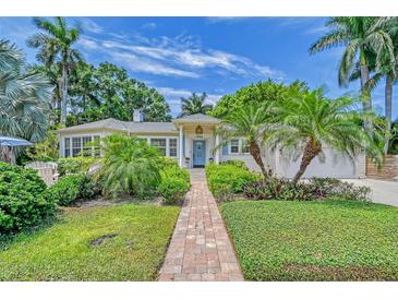 Charming home featuring a brick walkway, lush landscaping, and a welcoming blue front door at 1960 Lincoln Dr, Sarasota, FL 34236
