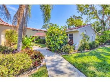 Beautiful front exterior of home with mature landscaping and red tile roof at 2267 Pueblo Ln # V40, Sarasota, FL 34231
