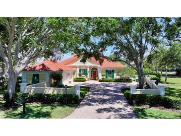 Charming one story home with brick driveway, lush green yard, and mature trees at 228 Saint James Park, Osprey, FL 34229