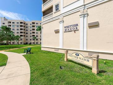 Exterior view of Whittier Manor building with guest parking sign surrounded by lush green lawn and landscaping at 3730 Cadbury Cir # 631, Venice, FL 34293