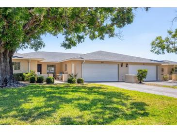 Charming condo with an attached two-car garage, manicured lawn, and mature shade trees at 7069 W Country Club N Dr # 7069, Sarasota, FL 34243