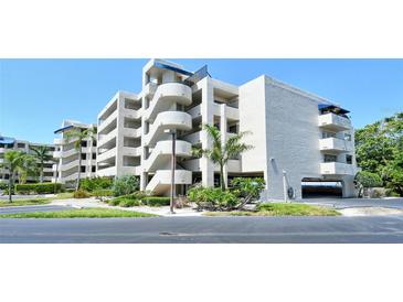 Low angle view of a condo building featuring well-kept landscaping and a unique circular stairway design at 835 S Osprey Ave # 310, Sarasota, FL 34236