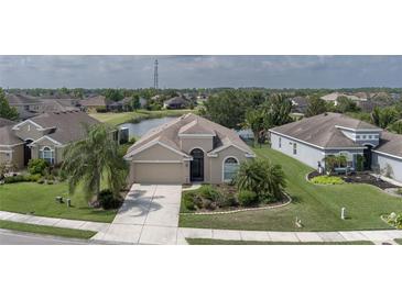Inviting single-story home with a well-manicured lawn, complemented by lush landscaping and a tranquil pond view at 11319 82Nd E St, Parrish, FL 34219