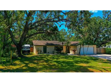 Charming single-story home features a lush, green lawn and mature, shady trees at 1613 6Th W St, Palmetto, FL 34221