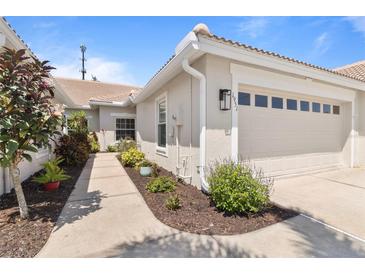 Charming home exterior with well-manicured landscaping, tile roof, and attached garage at 1951 San Silvestro Dr, Venice, FL 34285