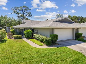 Well-maintained home with a charming gray exterior, attached garage, and manicured landscaping at 3921 Center Gate Cir # 11, Sarasota, FL 34233