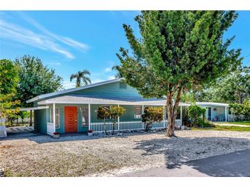 Inviting home with a vibrant orange door and beautiful landscaping at 4105 Rockefeller Ave, Sarasota, FL 34231