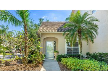 Charming home featuring lush landscaping and a welcoming front entrance with glass door at 6770 Fairway Gardens Dr, Bradenton, FL 34203
