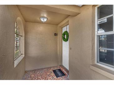 Covered front porch with tiled flooring and decorative window at 9430 Glen Moor Ln, Port Richey, FL 34668