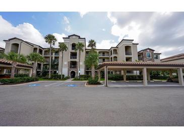 Attractive multi-story condo building with lush landscaping, covered parking, and visible accessibility parking at 17118 Vardon Ter # 307, Bradenton, FL 34211