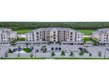 Exterior view of the condominium building with covered parking and manicured landscaping at 17902 Gawthrop Dr # 401, Bradenton, FL 34211