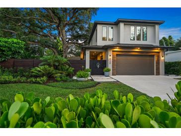 Stunning two-story home with lush landscaping, a modern design, and a finished two car garage at 2124 Wisteria St, Sarasota, FL 34239
