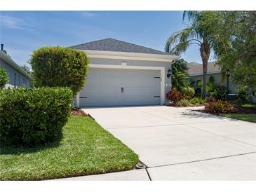 Well-maintained two-car garage with a concrete driveway and attractive landscaping at 4318 Deep Creek Ter, Parrish, FL 34219