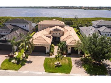 Expansive estate with a red tile roof, lush landscaping, and an adjacent waterway view at 5502 Tidewater Preserve Blvd, Bradenton, FL 34208