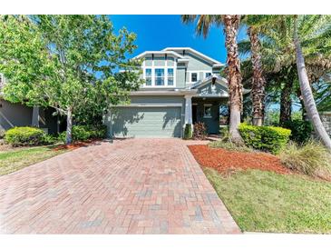 Charming two-story home with brick driveway, lush landscaping, and inviting curb appeal at 8243 Nandina Dr, Sarasota, FL 34240