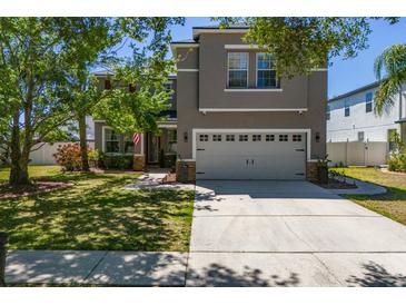 Charming two-story home with a manicured lawn and two-car garage at 10615 Boyette Creek Blvd, Riverview, FL 33569