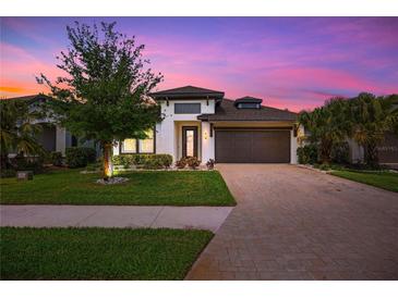 Charming single-Gathering home with a paved driveway, lush lawn, and well-maintained landscaping at 14514 20Th E St, Parrish, FL 34219
