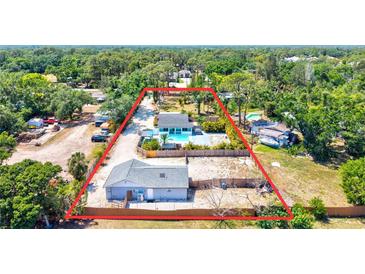 Aerial view of home on large lot with inground pool, studio, and fenced yard at 1518 Stoeber Ave, Sarasota, FL 34232
