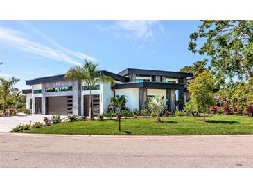 Modern home showcasing stylish architectural details, well-maintained landscaping, and a lush green lawn at 1555 Eastbrook Dr, Sarasota, FL 34231