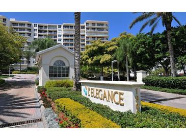 Elegance Condo community entrance with lush landscaping and brick paved drive at 1800 Benjamin Franklin Dr # B310, Sarasota, FL 34236