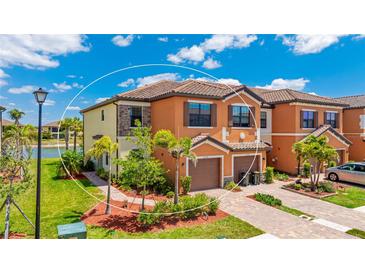 Beautiful two-story townhome with attached garage, landscaping, and view of the lake at 20398 Lagente Cir, Venice, FL 34293