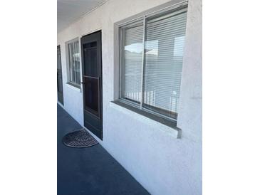 Condo exterior shows the front door and window with a white stucco finish at 3101 Bee Ridge Rd # 221, Sarasota, FL 34239
