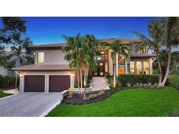 Stunning two-story home with tropical landscaping, tile roof, and a two-car garage at 3272 Bayou Rd, Longboat Key, FL 34228