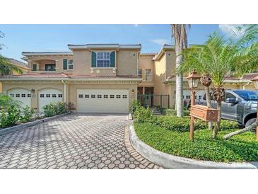 Charming townhouse featuring a two-car garage, a patterned driveway and lush landscaping at 3623 Square West Ln # 5, Sarasota, FL 34238