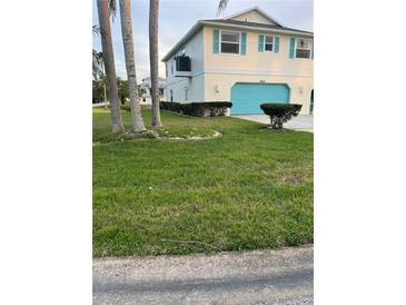 Charming two-story home featuring a blue garage door and light-colored siding, complemented by a well-maintained front lawn at 4066 Amberjack Dr, Hernando Beach, FL 34607