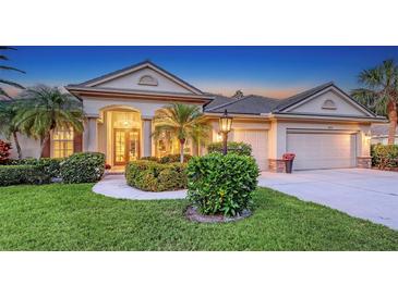 Charming one-story home featuring a well-manicured lawn, tropical landscaping, and a welcoming entrance with double doors at 4832 Carrington Cir, Sarasota, FL 34243