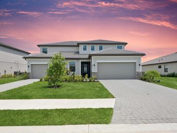 Stunning two-story home featuring a three-car garage, manicured lawn, and beautiful landscaping at 4951 Oyster Pearl St, Lakewood Ranch, FL 34211