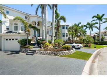 Stunning two-story home with lush landscaping, grey driveway pavers, and a two-car garage at 7118 Hawks Harbor Cir, Bradenton, FL 34207