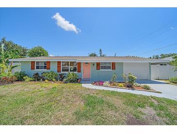 Charming single-story home with light blue exterior, wood shutters, peach-colored door, and landscaped front yard at 130 E Seminole Dr, Venice, FL 34293