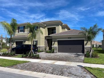 Beautiful two-story home with a two-car garage, landscaped yard and stone detailing on the facade at 3375 Juniper Springs St, Wesley Chapel, FL 33543