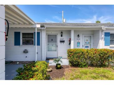 Charming single-story home featuring white siding, blue shutters and a well-maintained front garden at 6047 Arlene Way, Bradenton, FL 34207