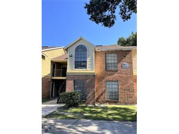 Two-story condo unit with brick facade, green grass and updated windows in well-maintained community at 8617 Fancy Finch Dr # 102, Tampa, FL 33614