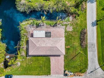 Stunning aerial view of home, with a tile roof, brick driveway, and waterfront access at 9080 Caloosa Dr, Venice, FL 34293
