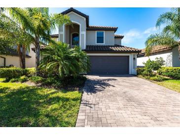 Charming two-story home with a paved driveway and a two-car garage, surrounded by lush landscaping at 11510 Sweetgrass Dr, Bradenton, FL 34212
